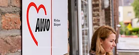 Eine Frau steht vor dem Eingang der AWO.